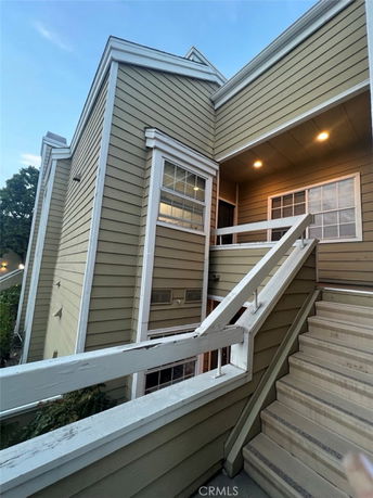 Front view of a multi-story building with stairs leading to the entrance.