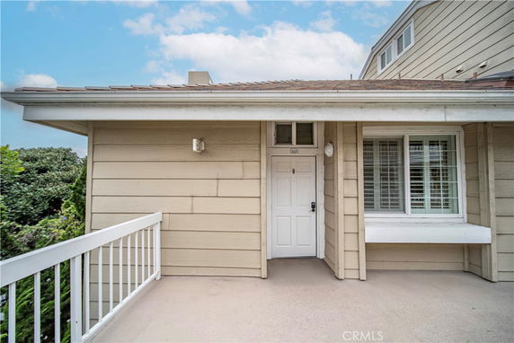 Front view of a house with a beige exterior and white front door.