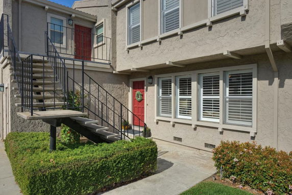 Front view of a building with exterior staircase leading to a second floor entrance.