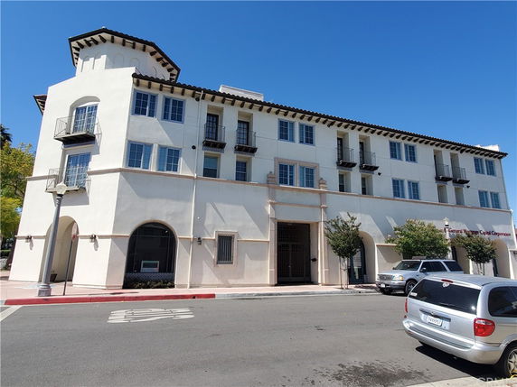 Front view of a multi-story building with arched entrances and balconies.