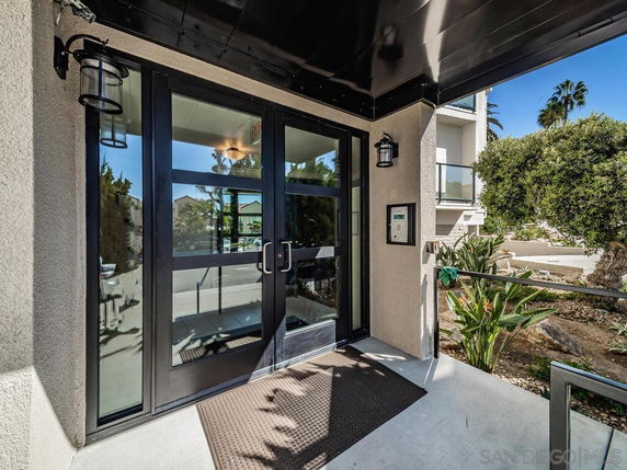 Front view of a building entrance with glass doors and outdoor lighting.