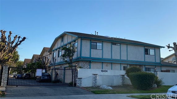 Front view of a two-story building with gated entrance.