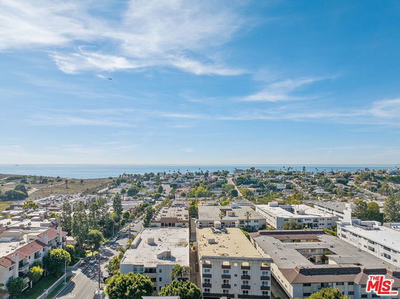 Panoramic view of a cityscape with residential buildings and the ocean in the distance.