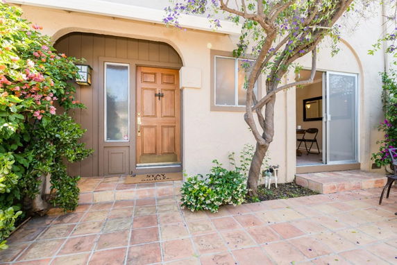 Front view of a house entrance with wooden door and sliding glass door.
