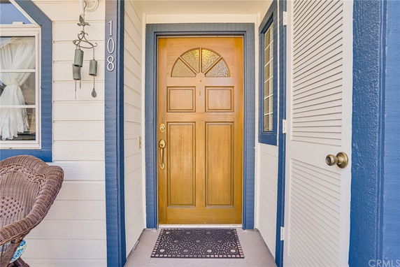 Front view of a house entryway with a wooden door and blue trim.