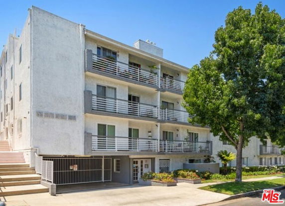 Front view of a multi-story apartment building with balconies.