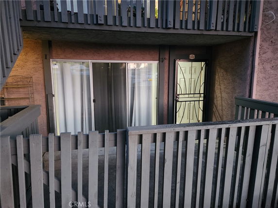 Front view of a multi-level building with sliding doors and a gated entrance.