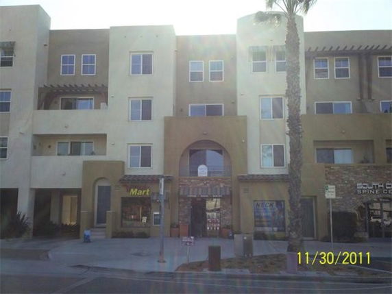 Front view of a multi-story building with retail spaces on the ground floor.