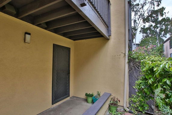 Exterior corner view of a building with a covered porch and metal door.
