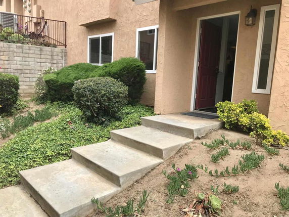 Front view of a house with steps leading to a door.