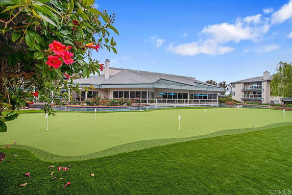 Front view of a large building with a putting green in front.