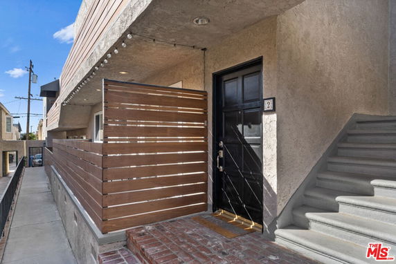 Entrance view of a building with wooden paneling and a staircase.