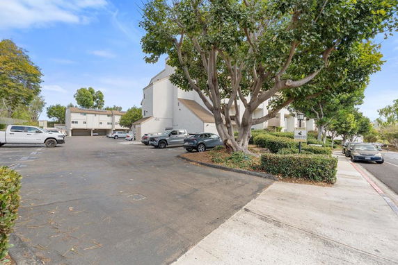 Outdoor parking area in front of multi-story residential buildings.