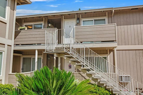 Front view of a two-story building with exterior stairs and balconies.