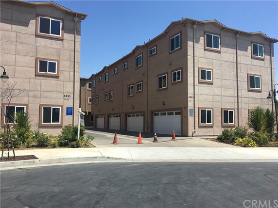 Front view of a multi-story residential building with garages.