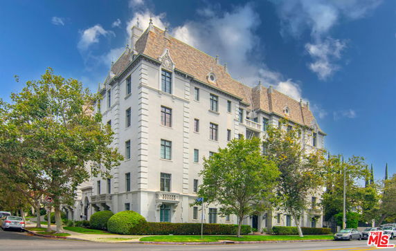 Front view of a multi-story building with ornate roof and decorative architectural details.