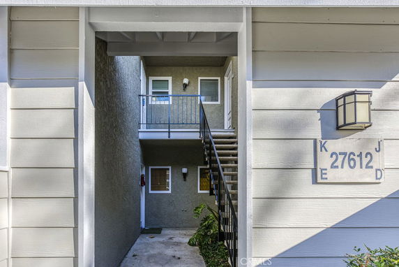 Entrance of a residential building with stairs leading to upper level.