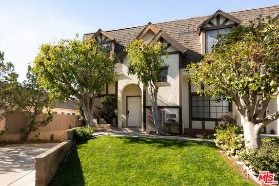 Front view of a house with a steep roof and Tudor-style design.
