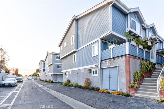 View of a multi-story residential building with blue siding and garage entrance.