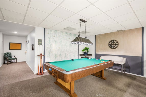 Indoor recreation area with a billiards table and seating.