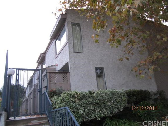 Front view of a multi-story residential building with gated entrance.