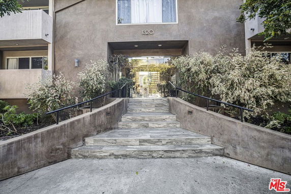 Front entrance of a building with stone steps leading up to a doorway.