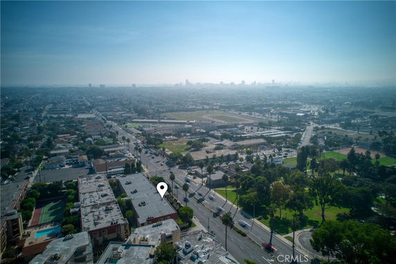 Aerial view of a cityscape with buildings, roads, and green areas.