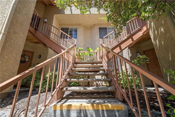 View of a building entrance with stairs leading to upper level.