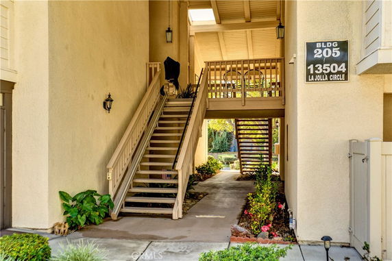 Front view of a residential building's entrance with staircases leading to upper floors.