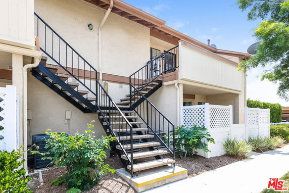 Front view of a two-story apartment building with exterior stairs.