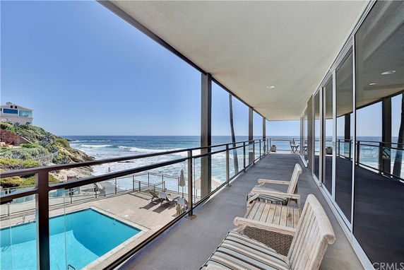 Balcony view overlooking the ocean with a swimming pool below.