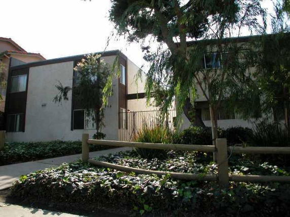 Front view of a two-story residential building with a garden in front.