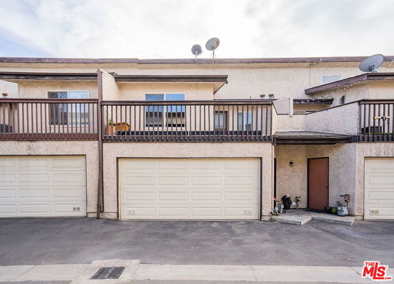 Front view of a two-story building with double garages and a balcony.
