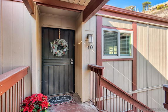 Front view of a house entrance with a decorative wreath on the door.