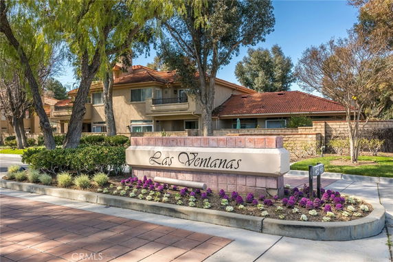 Front view of a residential building with a red-tiled roof and balconies, featuring a sign labeled 'Las Ventanas'.