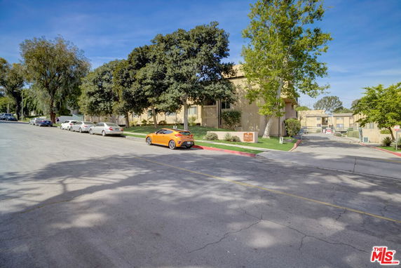Front view of a residential apartment building with trees around it.