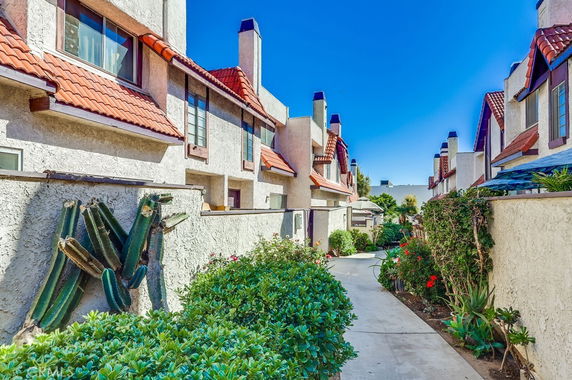 Front view of houses with red tiled roofs and chimney stacks.