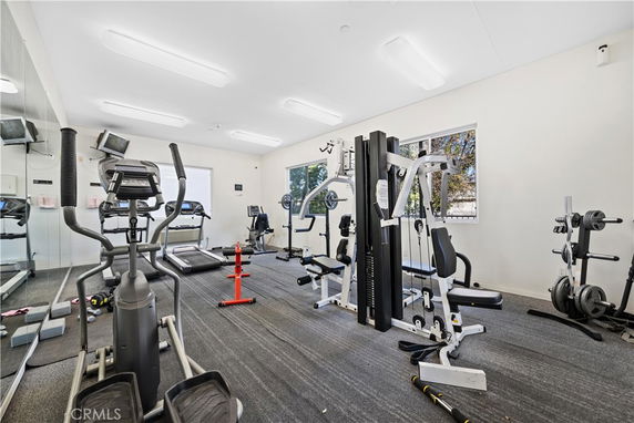 Indoor gym area with exercise equipment and machines.