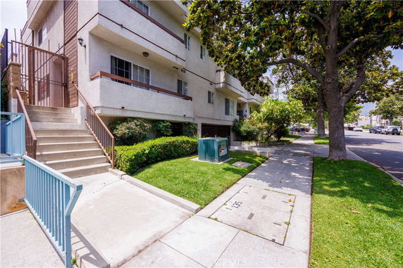 Front view of a multi-story apartment building with balconies.