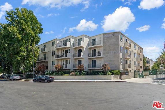Front view of a multi-story apartment building with balconies.