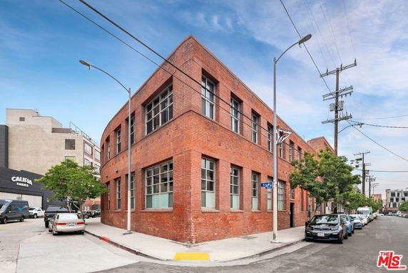 Front view of a brick two-story commercial building on a street corner.