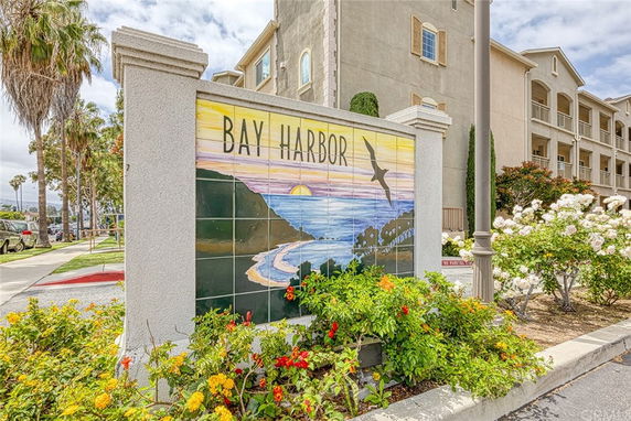 Front view of a residential building with three stories and a decorative Bay Harbor sign.