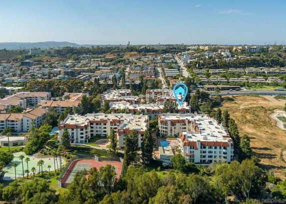 Aerial view of residential buildings and surrounding landscape.
