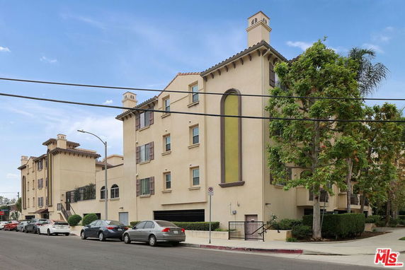 Front view of a multi-story building with beige exterior and multiple windows.