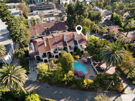 Aerial view of a multi-story building with red-tiled roofs and surrounding greenery.