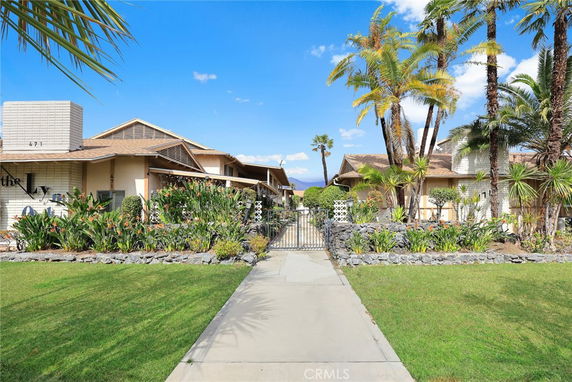 Front view of houses surrounded by landscaping with a gate entrance.