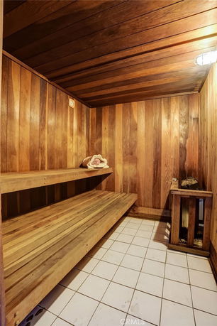 Interior view of a wooden sauna with benches and a heater.