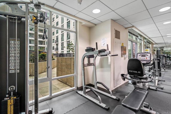 Interior view of a fitness center with exercise equipment and large windows.