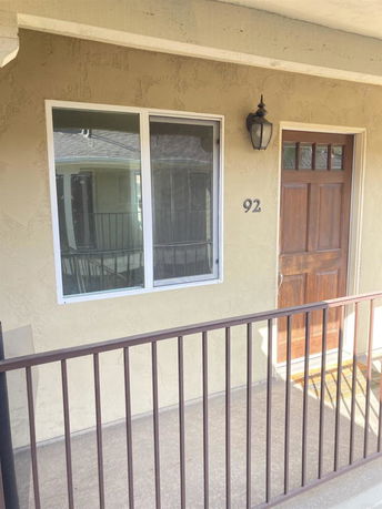 Front view of an entry door with an adjacent window on a beige-colored wall.