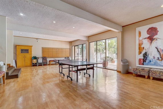 Open indoor space with a ping pong table and large windows.